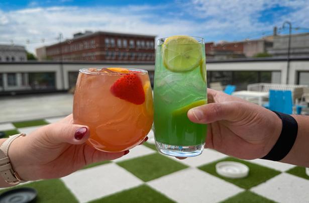 Two hands clink cocktails at Edgar's Above Broad in Augusta, GA